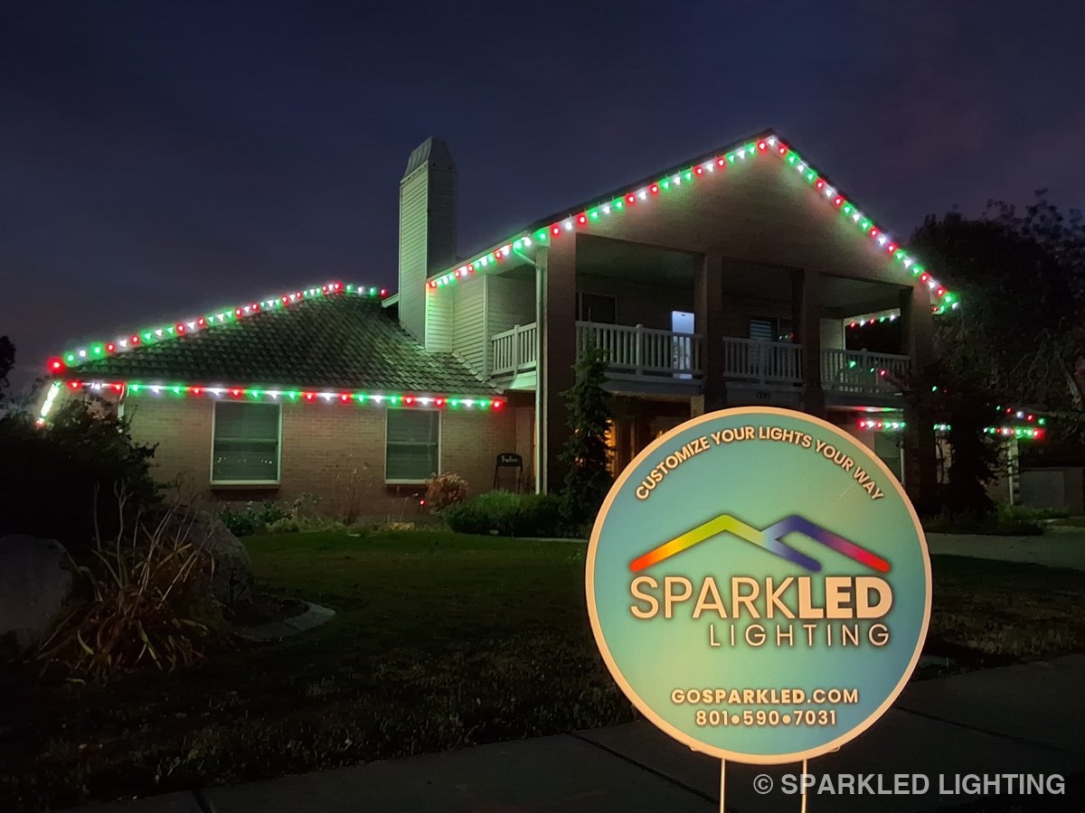 Christmas lights installed on a 2 story house on a Layton Utah home in red and green