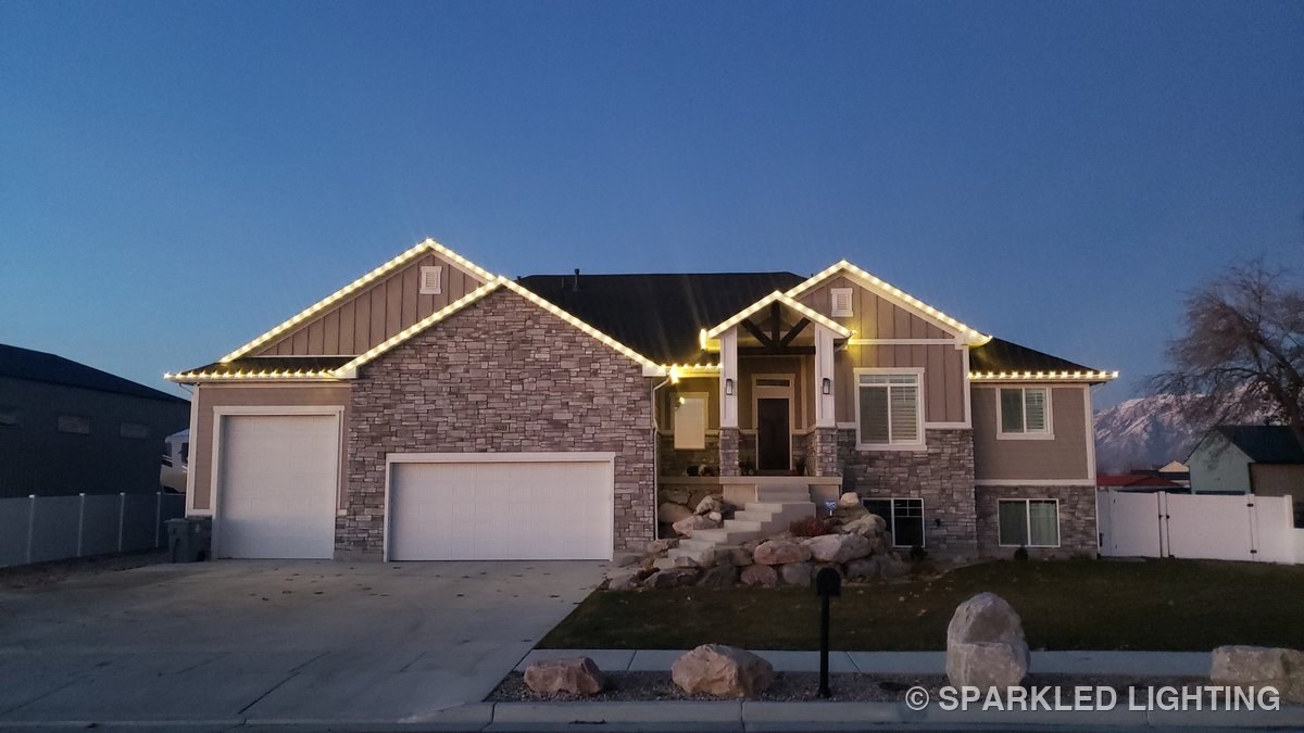 Christmas lights installed on a single story house on a Ogden Utah home in warm white