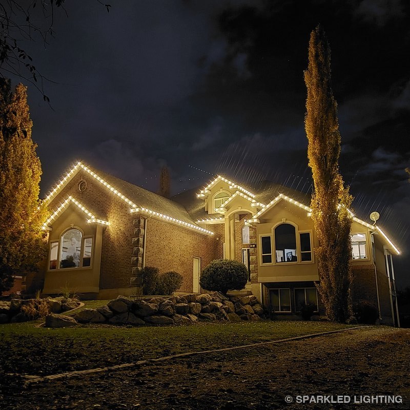 Christmas lights installed on a single story house on a Syracuse Utah home in warm white