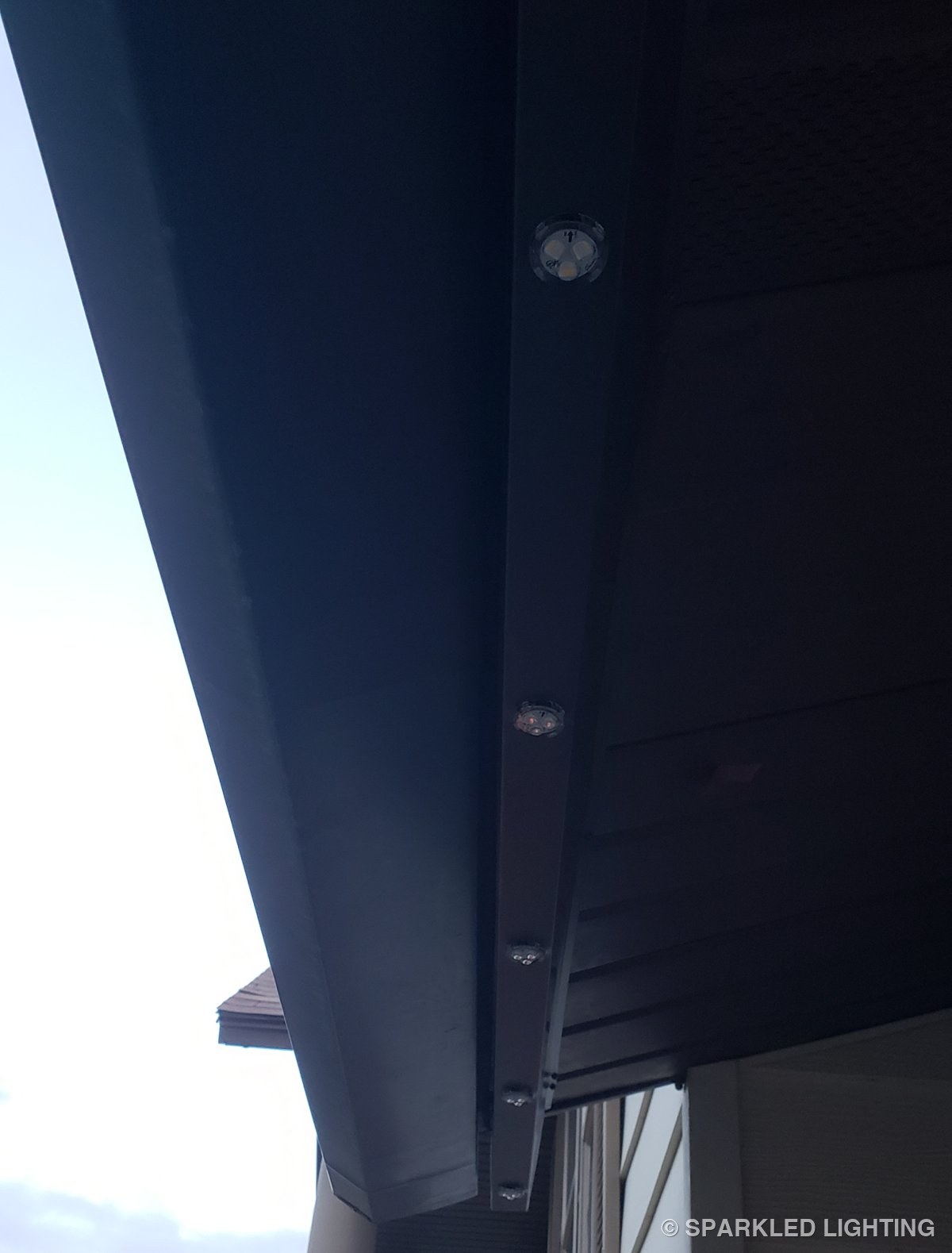 Color-matched channel blending into the dark fascia of a Roy Utah home in daylight