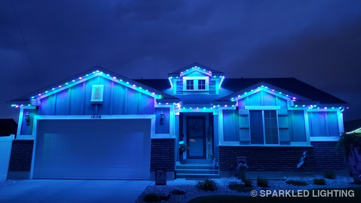 The same Clearfield Utah home lit in blue permanent LED lights