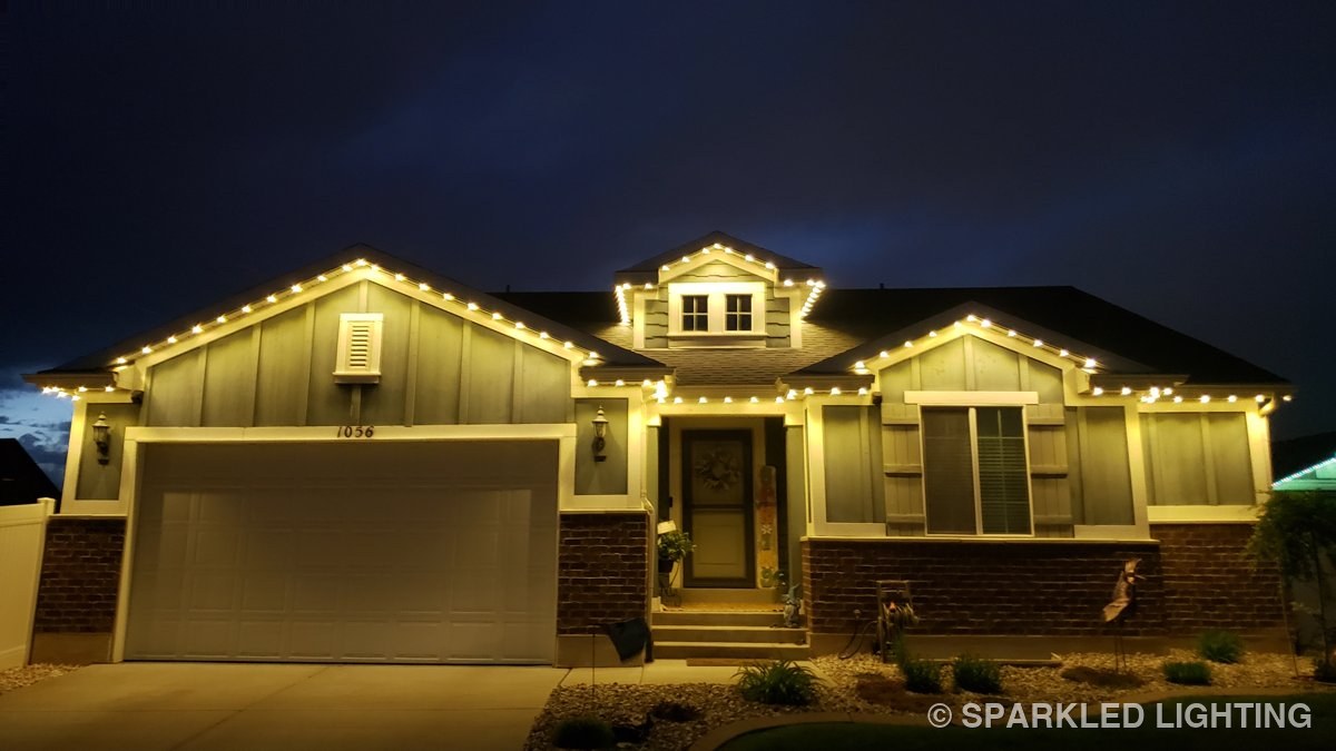 The same Clearfield Utah home lit in warm white permanent LED lights