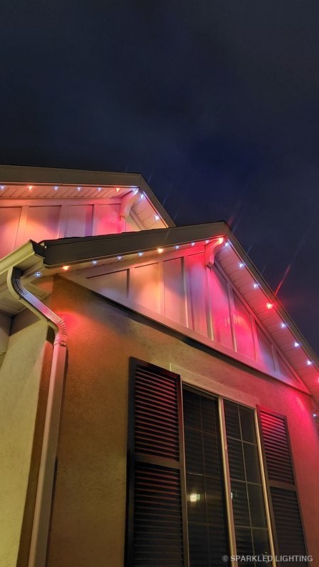 Permanent LED lights installed on gable close-up on a Clinton Utah home in pink