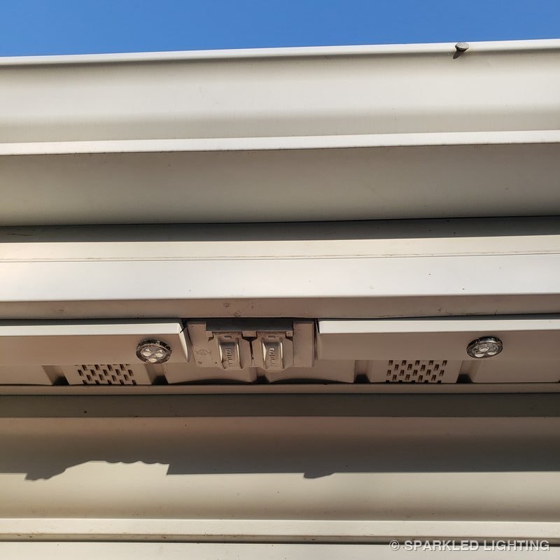Permanent LED lights installation close-up showing clean channel routing around an eave outlet