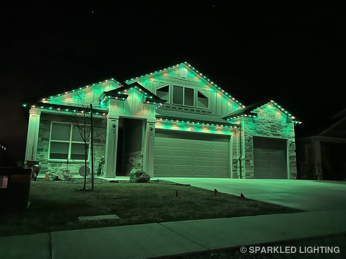 A single-story Hooper UT home at night with Sparkled Lighting permanent LED lights in solid green — St. Patrick's Day or year-round green theme