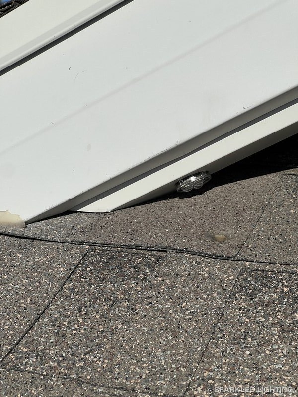 Permanent LED lights installation detail showing clean transition from gable end channel onto shingle roof