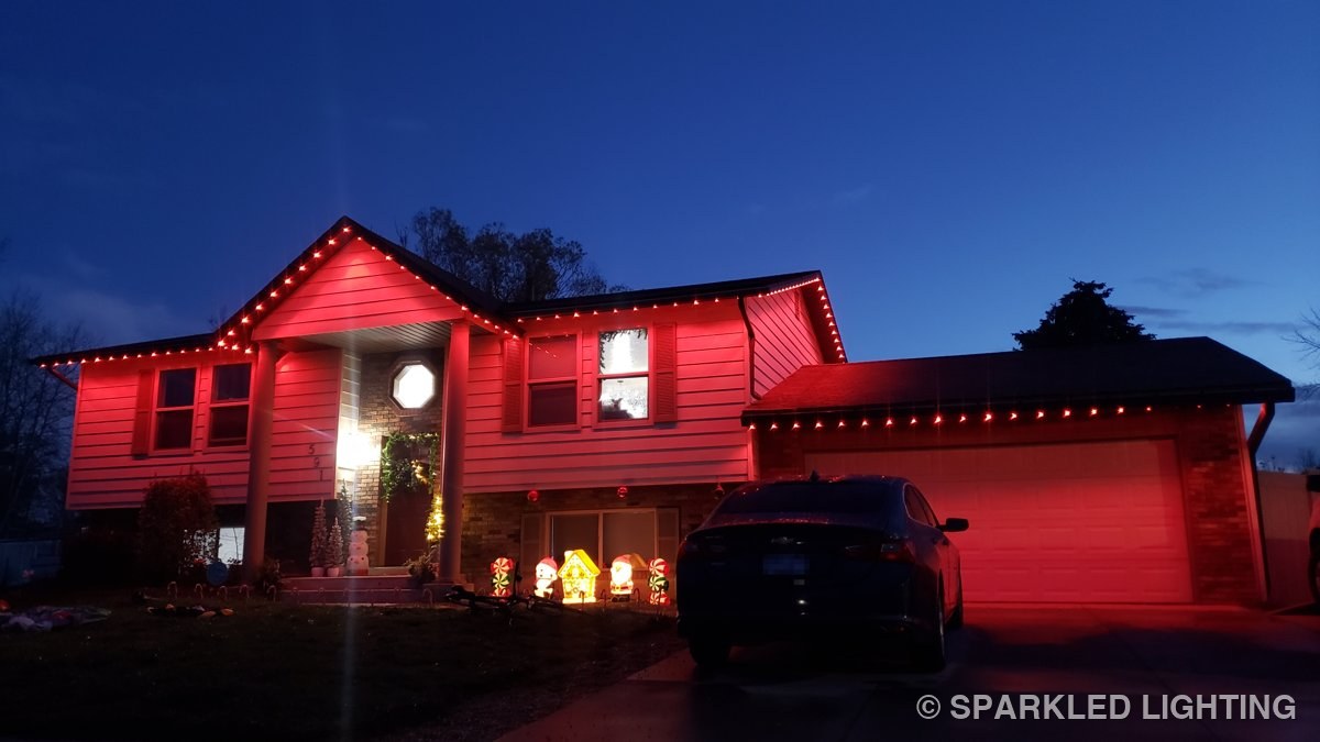 A Roy Utah two story home with permanent LED lights in solid Christmas red