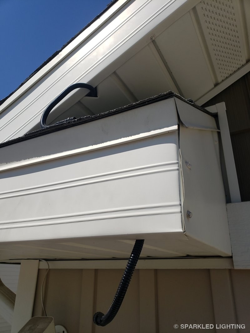 A clean concealed jump between rooflines on a Roy Utah permanent lighting install, photographed by the customer