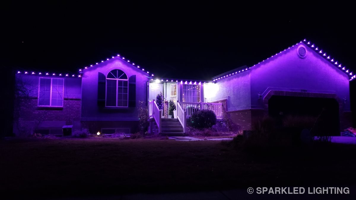 A single-story Syracuse UT home at night lit end to end in deep purple by Sparkled Lighting's RGBW LED system — the same pucks used on every SmartClip install