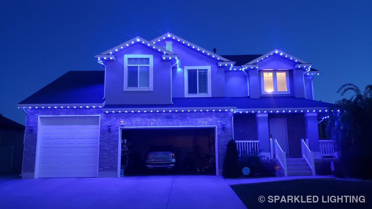 A Layton Utah two story home outlined in blue SmartClip LED lights at night