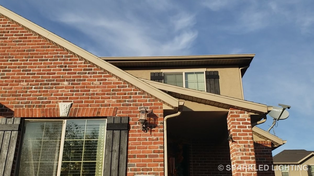 A brick West Point Utah home by day with SmartClip LED lights installed along the rooflines, nearly invisible against the trim